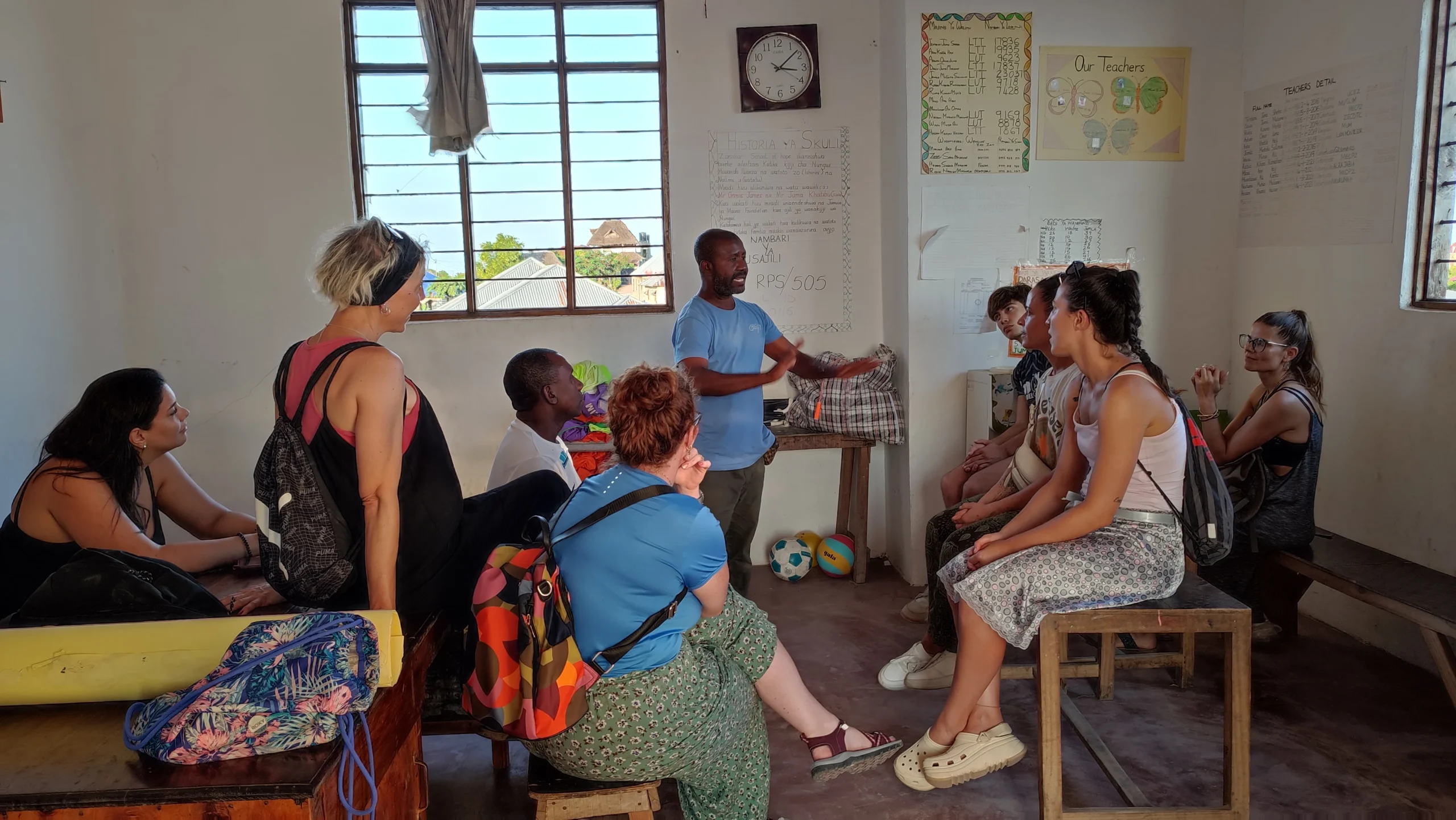 Grupo de viajeras de Mochilas con corazón en un colegio escuchando una charla local Grupo de viajeras de Mochilas con corazón en un colegio escuchando una charla local